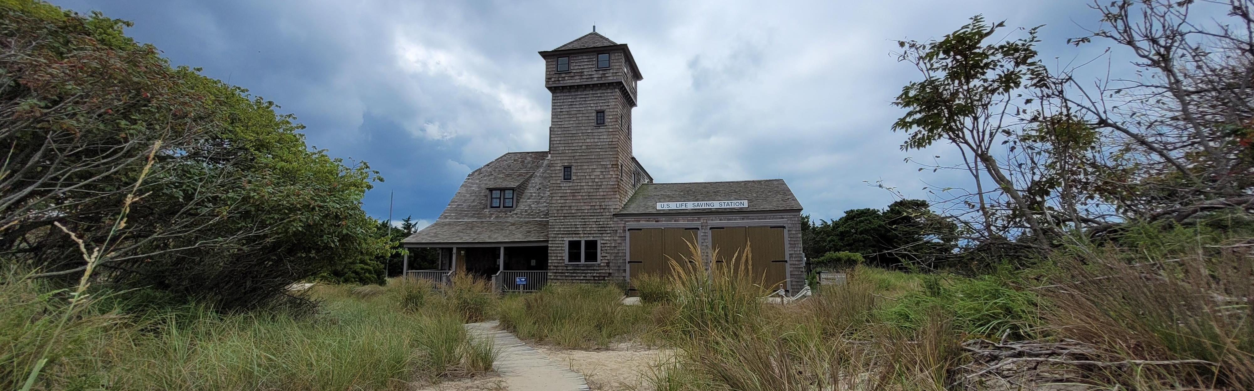 Historic wood shingled building amongst beach vegetation