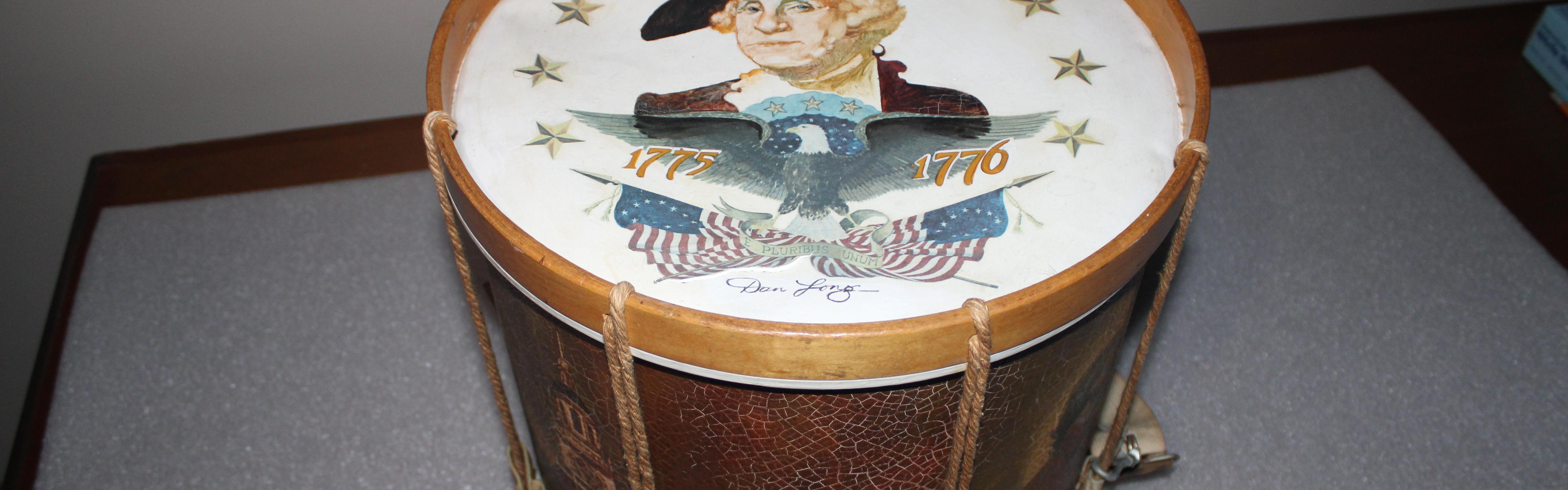 Drum featuring face and torso of man in white wig with black hat