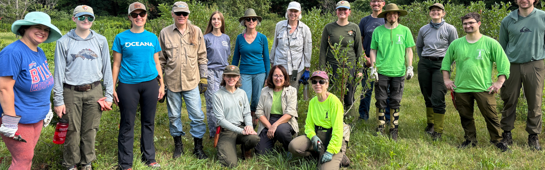 A group of national park rangers and volunteers gather for a picture outside.