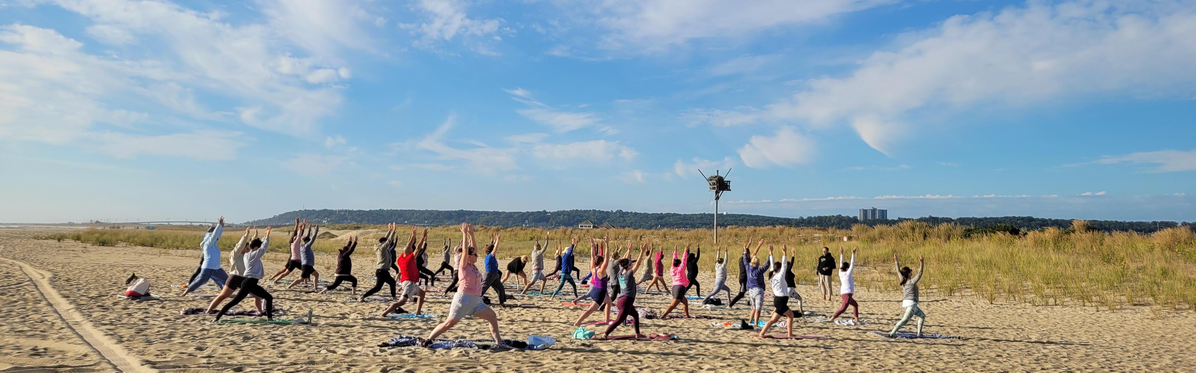 Group of people doing yoga on the beach