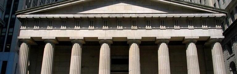 Federal Hall, a gray stone building with columns.