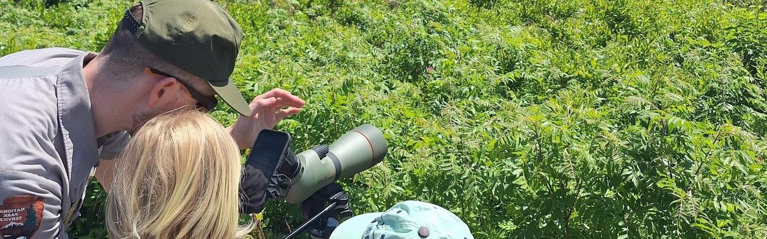 Park ranger with two Junior Rangers and a birding scope