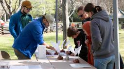 Park volunteers assist visitors with quill writing