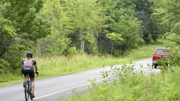 Single cyclist using the bike lane of a paved road while wearing proper safety gear