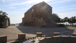 Outside view of visitor center, three-stories, brick with fountain in the foreground