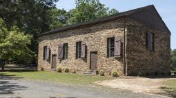 Image of a brown brick building, brown shutters and a brown roof