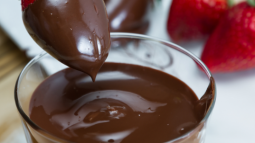 a photo of strawberries being dipped in chocolate