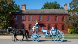 Tourists ride in a carriage at Colonial Williamsburg