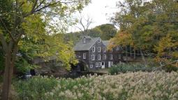 Scenic photograph of the Stony Brook Grist Mill alongside a creek