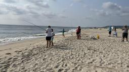 Group of people fishing on the beach
