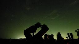 Shadow of ranger looking through telescope
