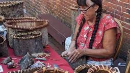Jennifer Lee demonstrates bark basket weaving in the Revere House courtyard