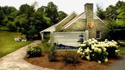 A stone building with an arrowhead logo on it & a sign that says, Museum of North Carolina Minerals