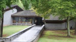 Stone Walkway leading up to Visitor Center. Grass area and trees on both sides of walkway.