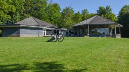 View showing visitor center building in background with cannon on the lawn