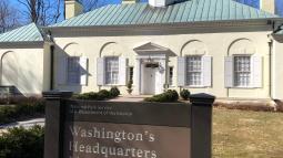 Front of Museum building with park sign in foreground reading "Washington's Headquarters Museum"