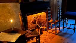 A tavern interior with candles and a fireplace