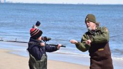 Ranger teaching child how to use fishing equipment