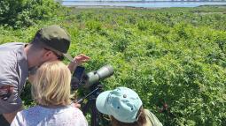 Park ranger with two Junior Rangers and a birding scope