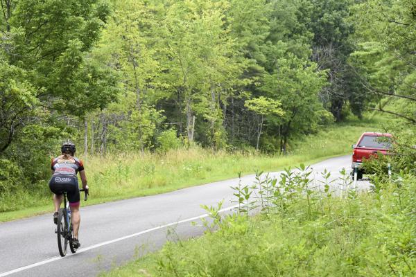 Single cyclist using the bike lane of a paved road while wearing proper safety gear