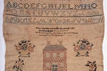 Piece of embroidery with letters, numbers, and house