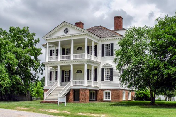 Kershaw House. Two stories of white siding levels with large porches on a brick foundation