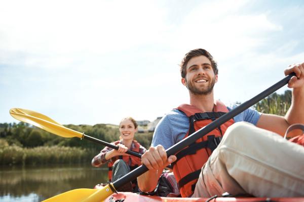 a woman and a man kayaking on water