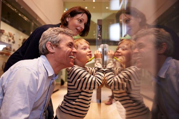 Image of a man, woman and child viewing objects behind glass in a musuem