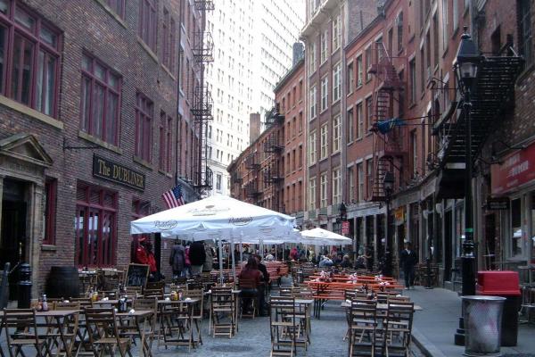 Chairs and umbrellas lining stone street in New York City