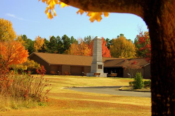 The Visitor Center and US Monument are framed by orange and yellow trees.