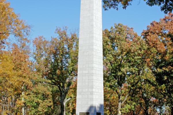 The US Monument is surrounded by trees that are turning orange and yellow.