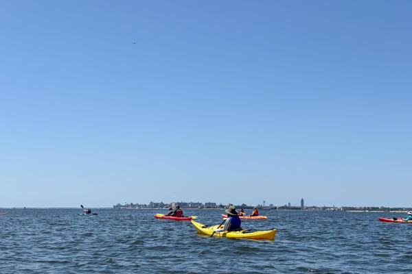 Group of kayakers with city skyline