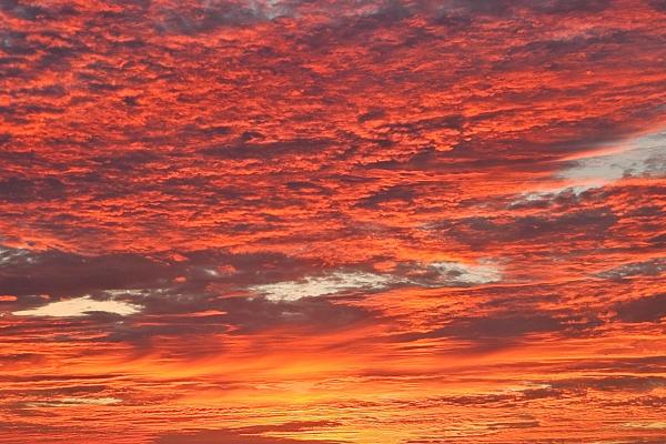 Red pink and orange sky over a body of water