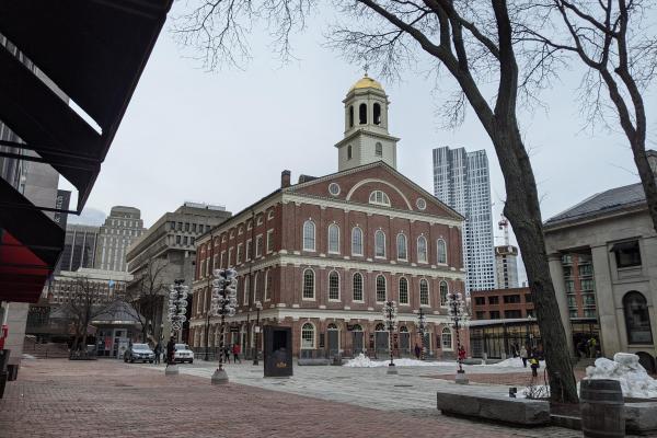 Brick three story building with a pediment creating a fourth story. Cupola with gilt dome sits atop.