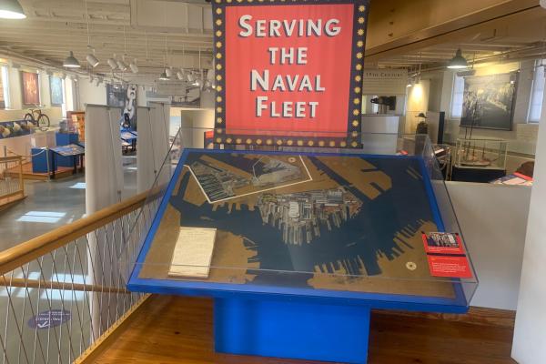 A diorama of a marine area sits under a banner reading "Serving the Naval Fleet"