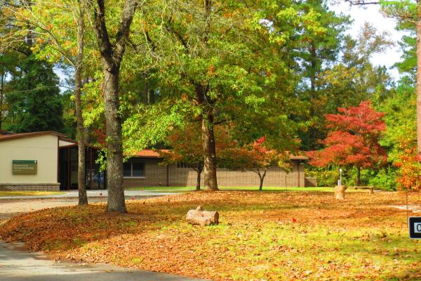 Moores Creek National Battlefield's Visitor Center with trees in front, on a sunny day.