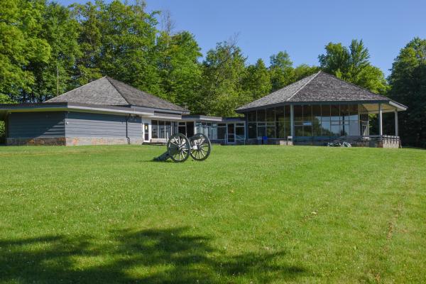 View showing visitor center building in background with cannon on the lawn