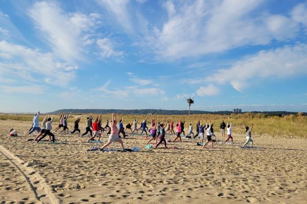 Group of people doing yoga on the beach