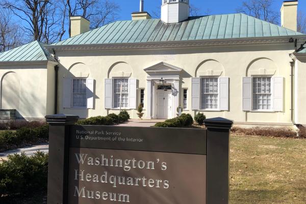 Front of Museum building with park sign in foreground reading "Washington's Headquarters Museum"