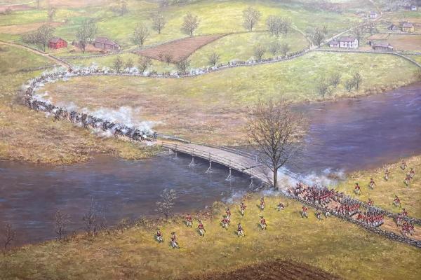 A painting of the North Bridge battle with a long column of minute men firing at British soldiers