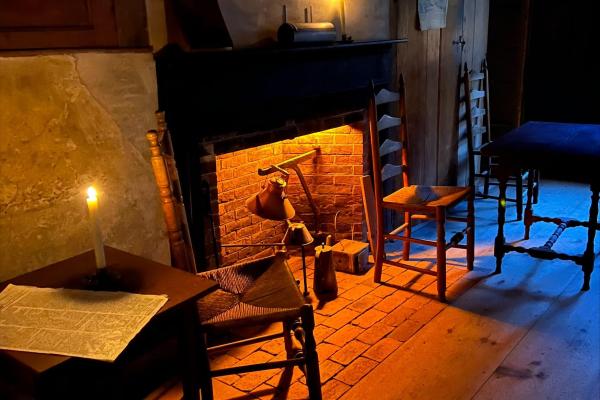 A tavern interior with candles and a fireplace