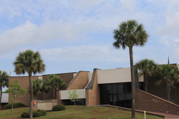 outside view of brick Fort Moultrie visitor center with entrance sign