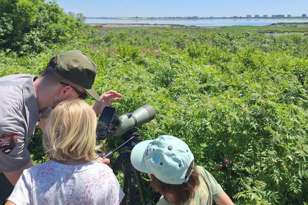 Park ranger with two Junior Rangers and a birding scope