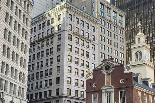 a 11 story granite building next to a historic brick building.