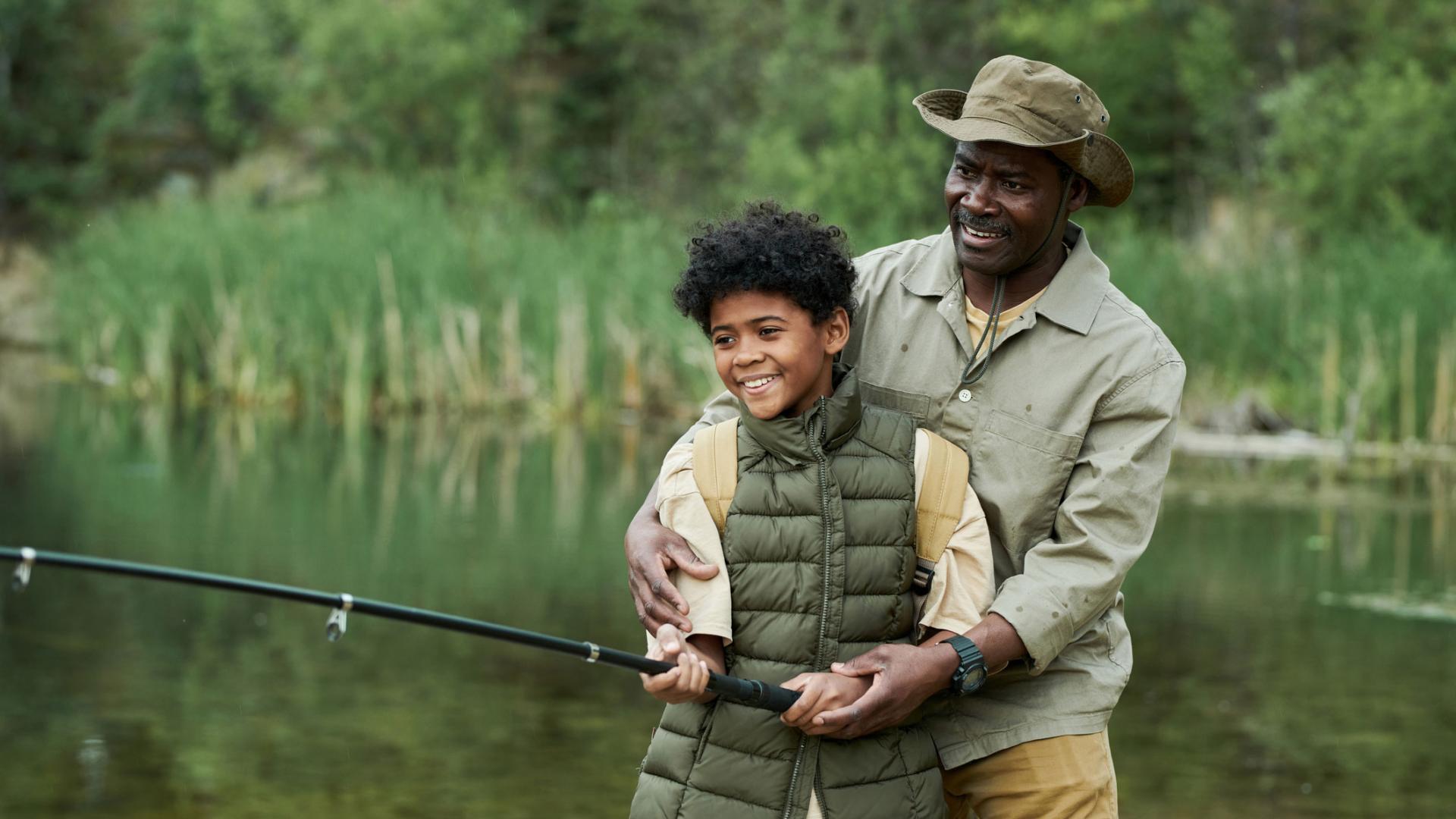 father and son fishing in a stream