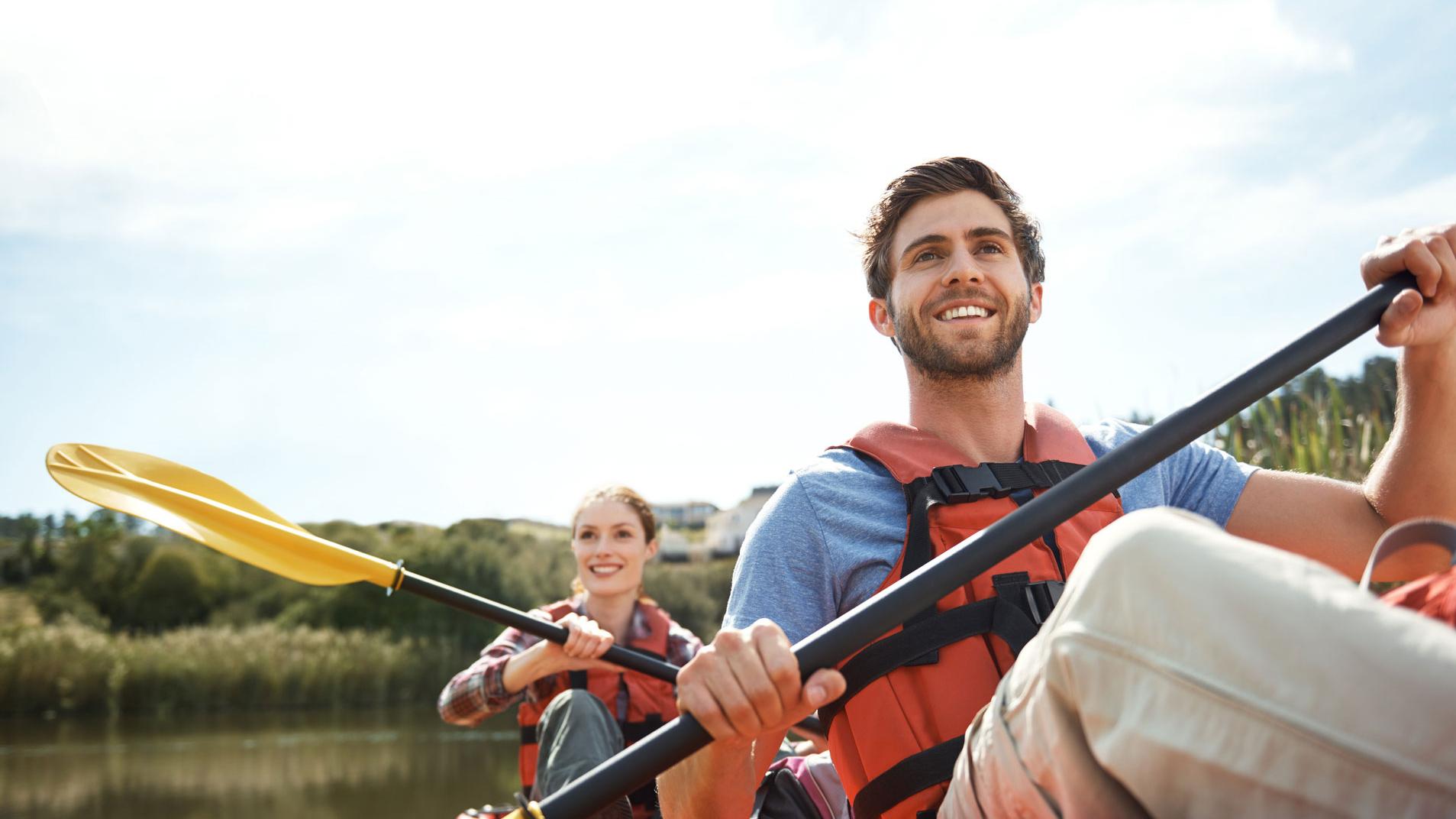a woman and a man kayaking on water