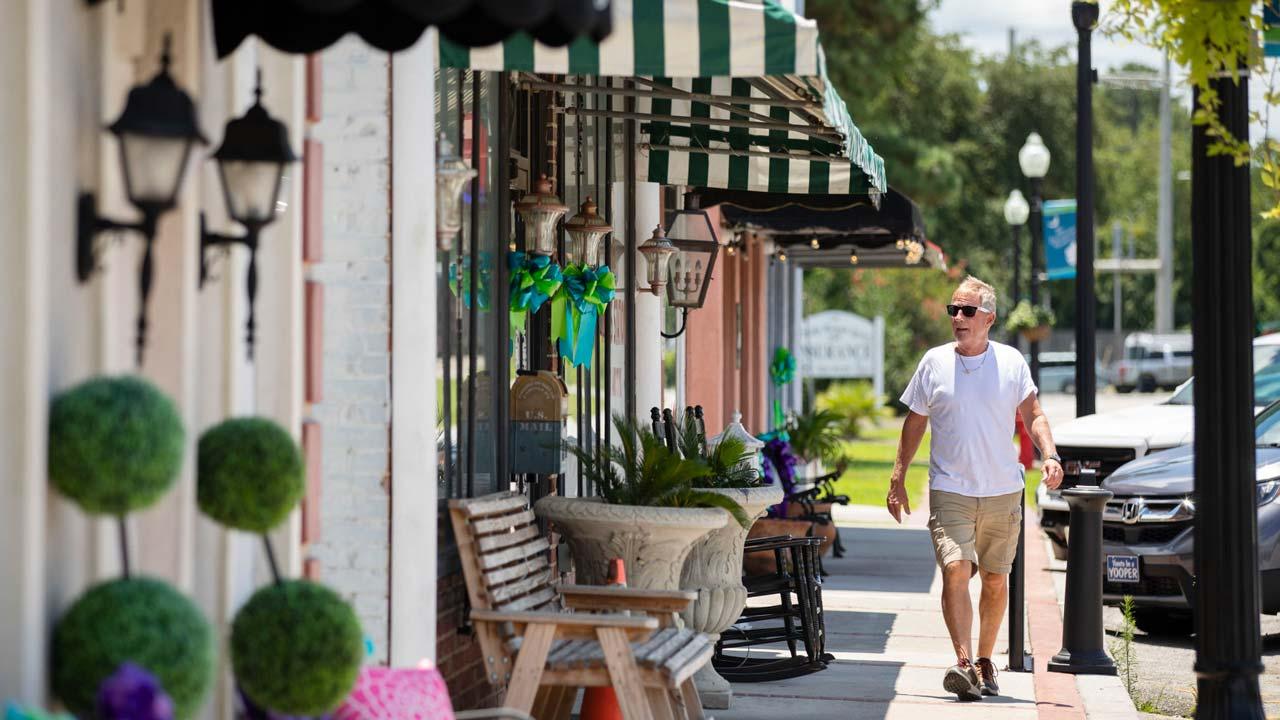 Man strolls along the shops of Main Street in Moncks Corner