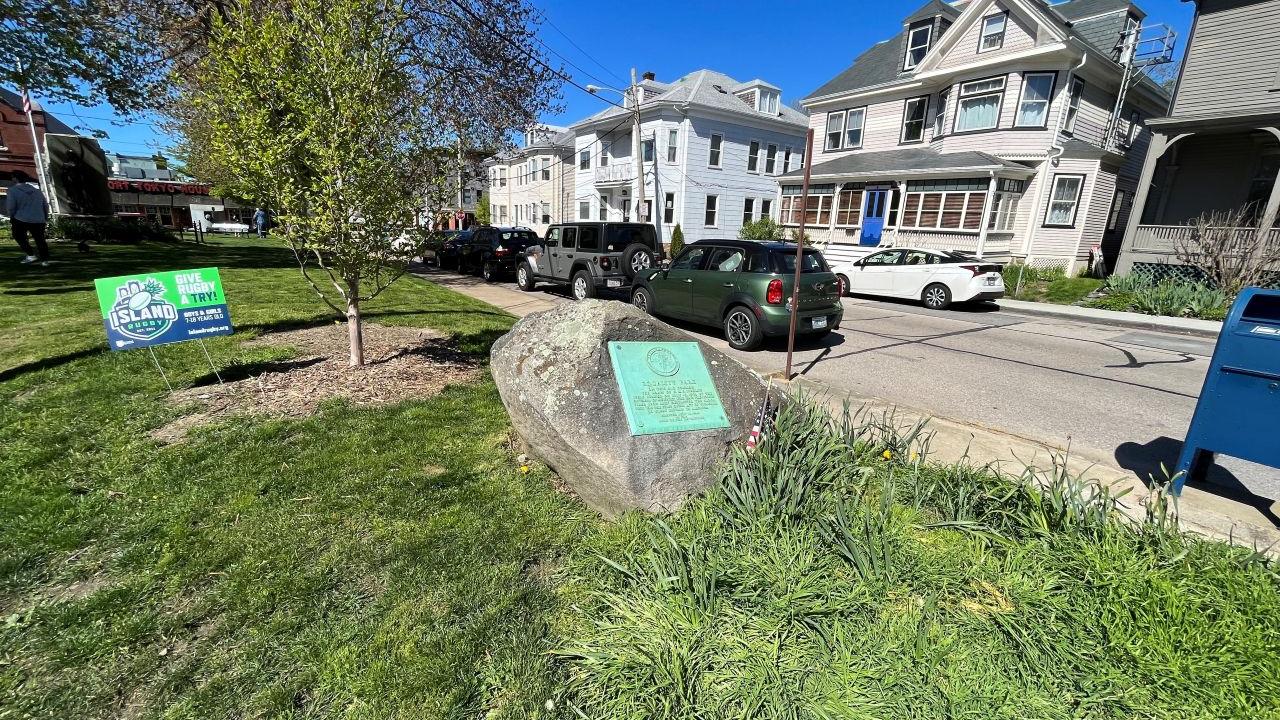A large boulder with a bronze plaque attached commemorating the burning of British ships.