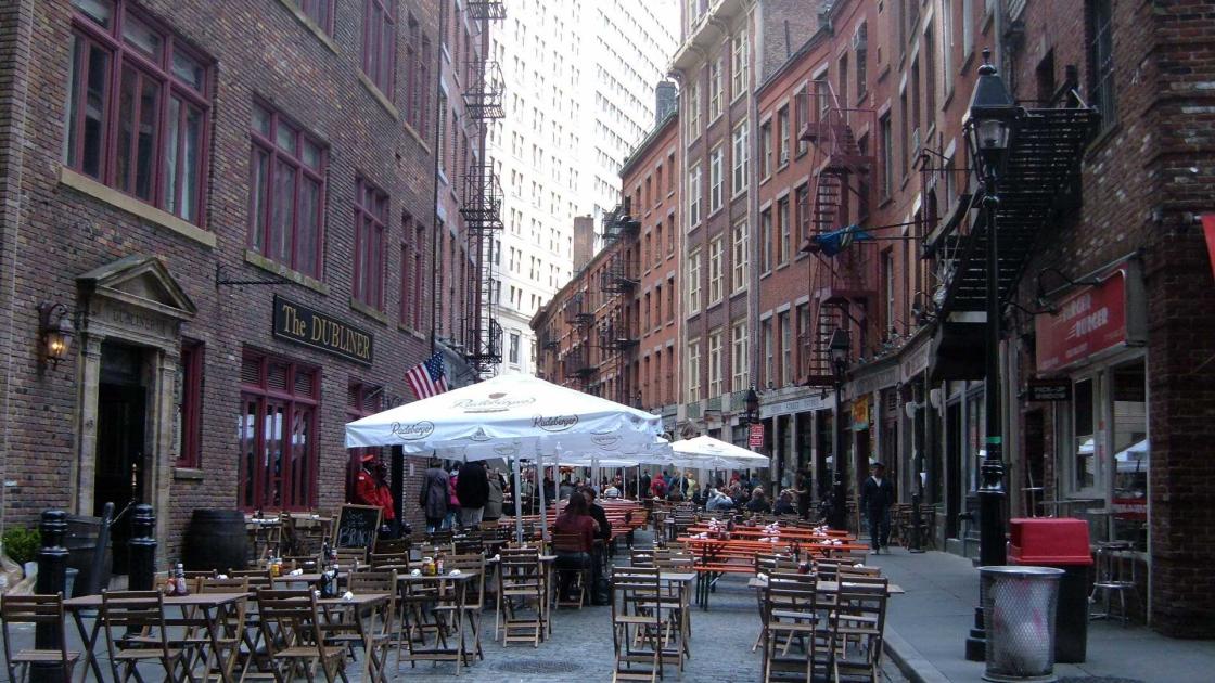 Chairs and umbrellas lining stone street in New York City